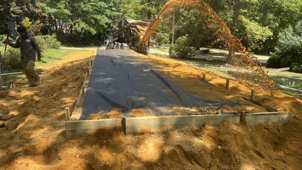 Sand being placed across a residential septic drainfield installation